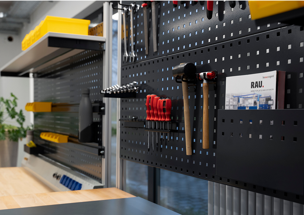 Werkzeugaufbewahrungsideen für effizientes und organisiertes Arbeiten Werkzeugwand mit verschiedenen Werkzeugen und Zubehör, darunter Schraubendreher, Hammer, Schraubenschlüssel, sowie gelbe Aufbewahrungsboxen und Regale.