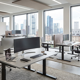 Modernes Großraumbüro mit elektrisch höhenverstellbaren Schreibtischen und Monitoren – ergonomische Arbeitsplatzlösungen.